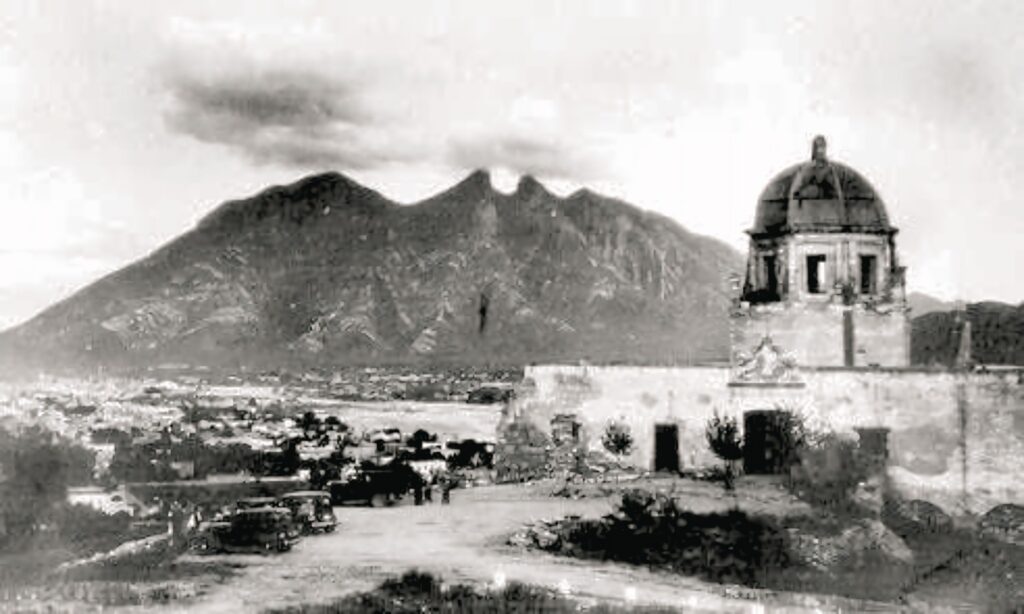 Fotografía antigua del Obispado de Monterrey en los años 30s, con autos de época y vista al Cerro de la Silla.